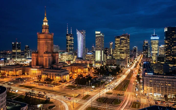 Warsaw's city centre at night, with the Palace of Culture and Science among lit office towers
